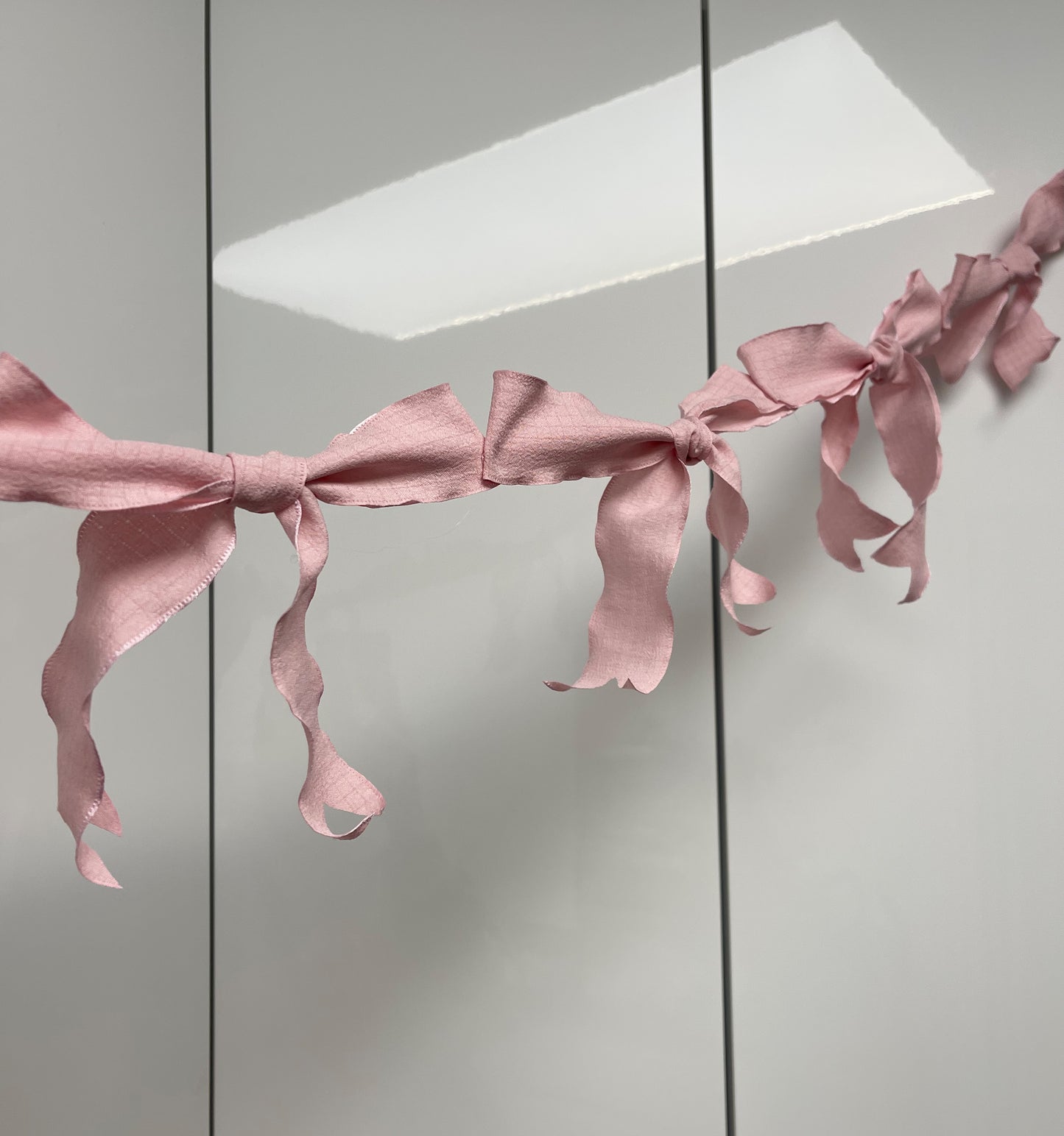 Pink Ribbon Bow Garland Hanging against white background. 10 Bows per garland.