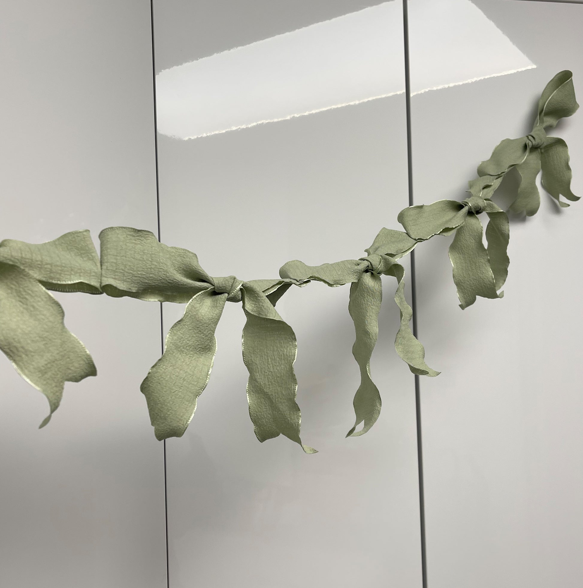 Ribbon Bow Garland Hanging against white background. 10 Bows per garland.