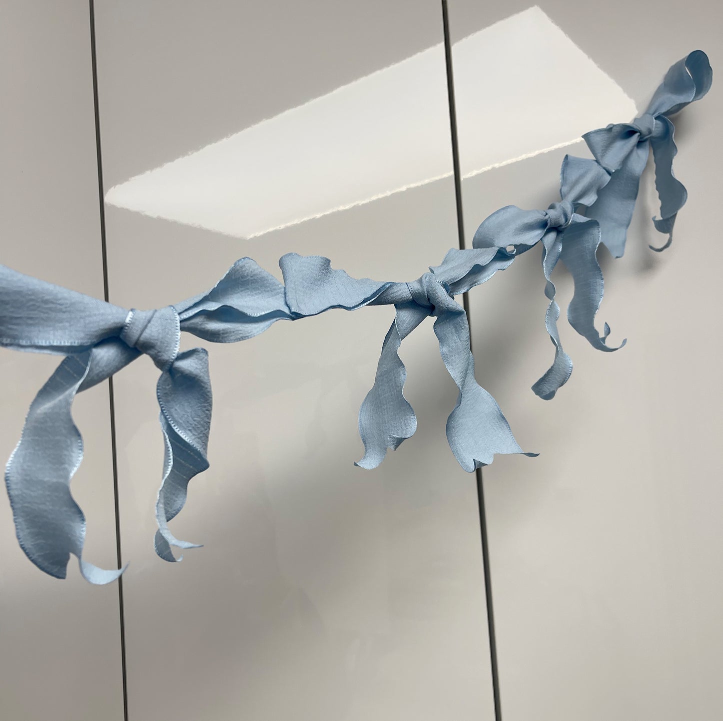 Ribbon Bow Garland Hanging against white background. 10 Bows per garland.