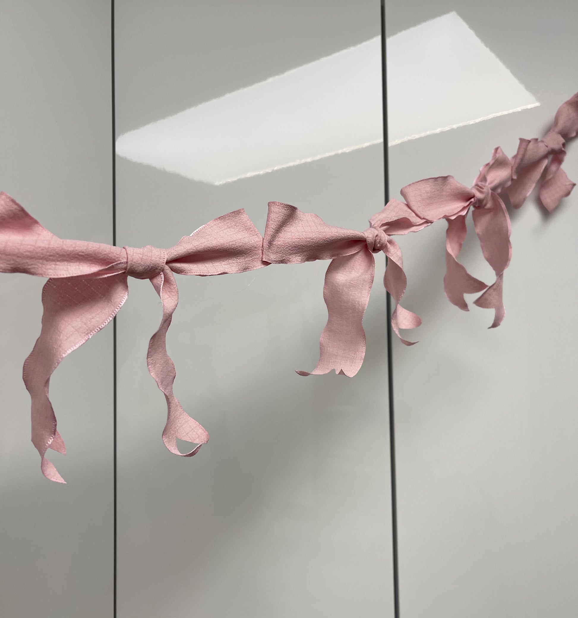 Pink Ribbon Bow Garland Hanging against white background. 10 Bows per garland.