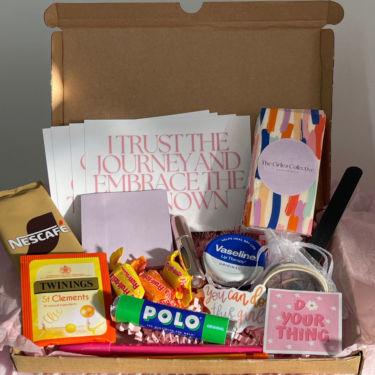 Image of 'New Job Essentials' Self-Care Gift Box which contains: 
Post It Notes
Pen and Pencil
Perfume Atomiser (perfume not included)
Vaseline
Tissues
Nail File
Positive Affirmation Cards
Coffee Sachet
Tea Bag
Sweet Chews
Polo Mints
Hair Bands
Hair Grips
Motivational Stickers
Plus a FREE The Girlies Collective Bookmark!